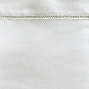May include: White fabric with a single row of stitching across the center.