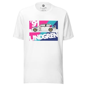 Può includere: T-shirt bianca con grafica di un'auto da corsa bianca, numero 10 e il nome "LINDGREN" in rosa e blu. L'auto ha ruote dorate e la scritta "Castrol". L'anno "91" è anch'esso visualizzato.