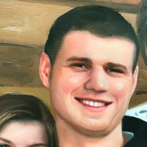 May include: A close-up portrait of a man with short brown hair. He is smiling and has a light complexion. He is wearing a black shirt.