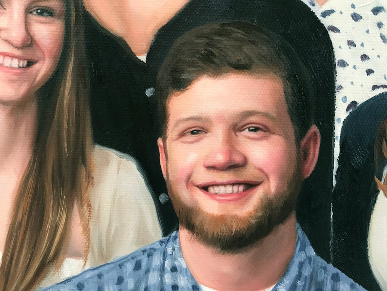 May include: A close-up portrait of a person with a beard and short brown hair. The person is smiling and wearing a blue and white patterned shirt.