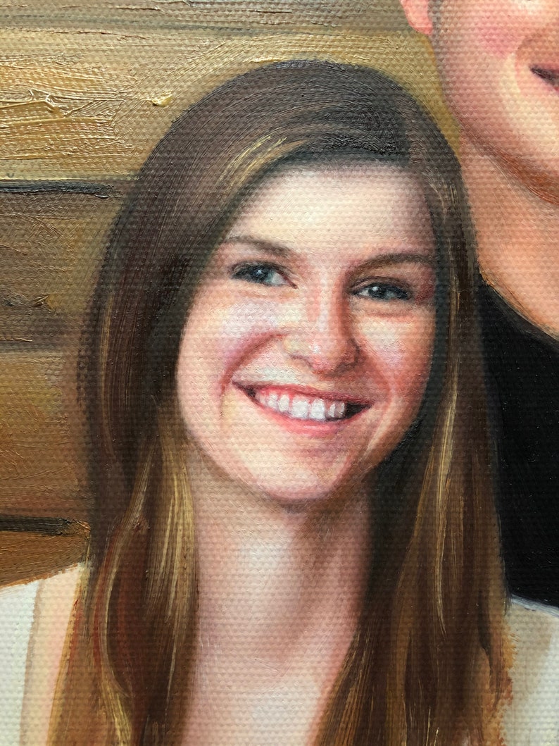 May include: A close-up portrait of a woman with long brown hair smiling. She is wearing a white top and has a warm, friendly expression.