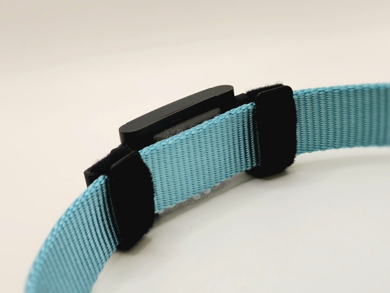 The Fi Series 3 collar adapter is attached to a non-Fi collar using two hook and loop straps with adjustable sliders