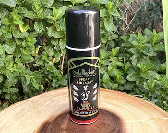 May include: A black cylindrical spray bottle of Siete Machos Locion Cologne Spray Urania. The label features white goat head illustrations, a central graphic, and text reading Siete Machos Locion Cologne Spray Urania, with a net content of 200 ml 6.75 oz.