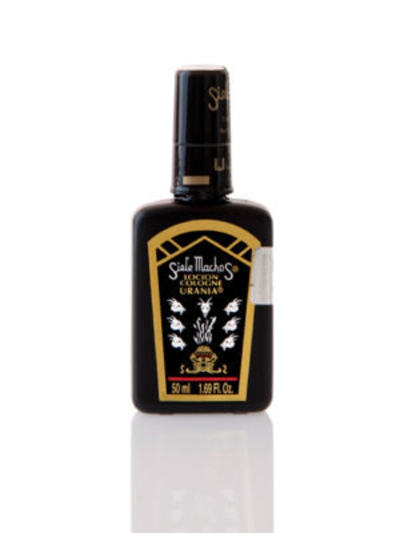 May include: A black cologne bottle with a gold label featuring the text "Siale Machos Locion Cologne Uranias". The bottle has a black cap and contains 1.69 fl oz (50 ml) of cologne.