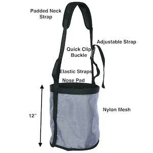 May include: A gray nylon mesh dog muzzle with a black padded neck strap, adjustable strap, and quick clip buckle. The muzzle has a black nose pad and elastic straps. The muzzle is 12 inches tall.