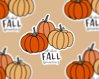 Puede incluir: Una pegatina con tres calabazas en tonos naranja y amarillo, con tallos verdes. El texto "all about FALL (prevention)" está incluido en el diseño. El fondo tiene imágenes borrosas de calabazas.