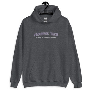 Puede incluir: Una sudadera con capucha gris oscuro con el texto "PROGRESS TECH SCHOOL OF URBAN PLANNING" en letras moradas con contorno.