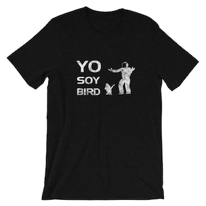 May include: Black t-shirt with a white graphic print of a person with a bird. The text on the shirt reads "YO SOY BIRD".