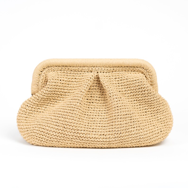 May include: A beige crocheted clutch bag with a rounded shape and a slightly textured surface.