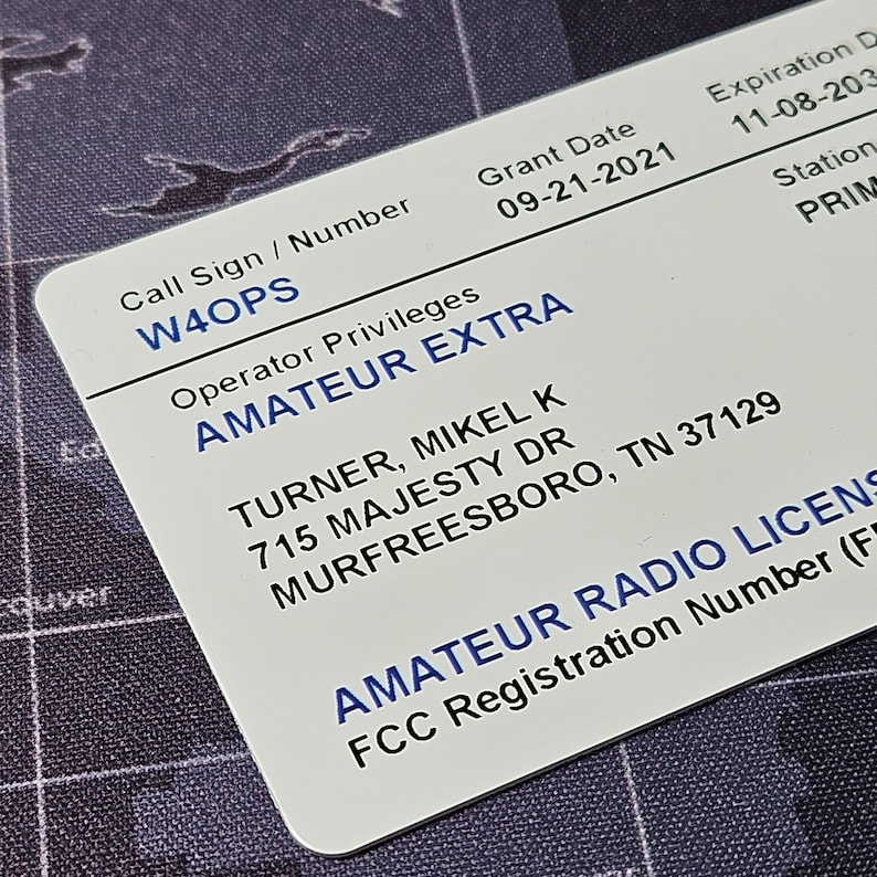 May include: White card with blue text. The card is a radio license for W4OPS, Amateur Extra class, issued to Mikel K Turner at 715 Majesty Dr, Murfreesboro, TN 37129. The grant date is 09-21-2021 and the expiration date is 11-08-2023.