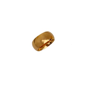 May include: A gold-colored ring with a rounded, smooth surface.