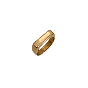 May include: A gold-toned ring with a rectangular band.