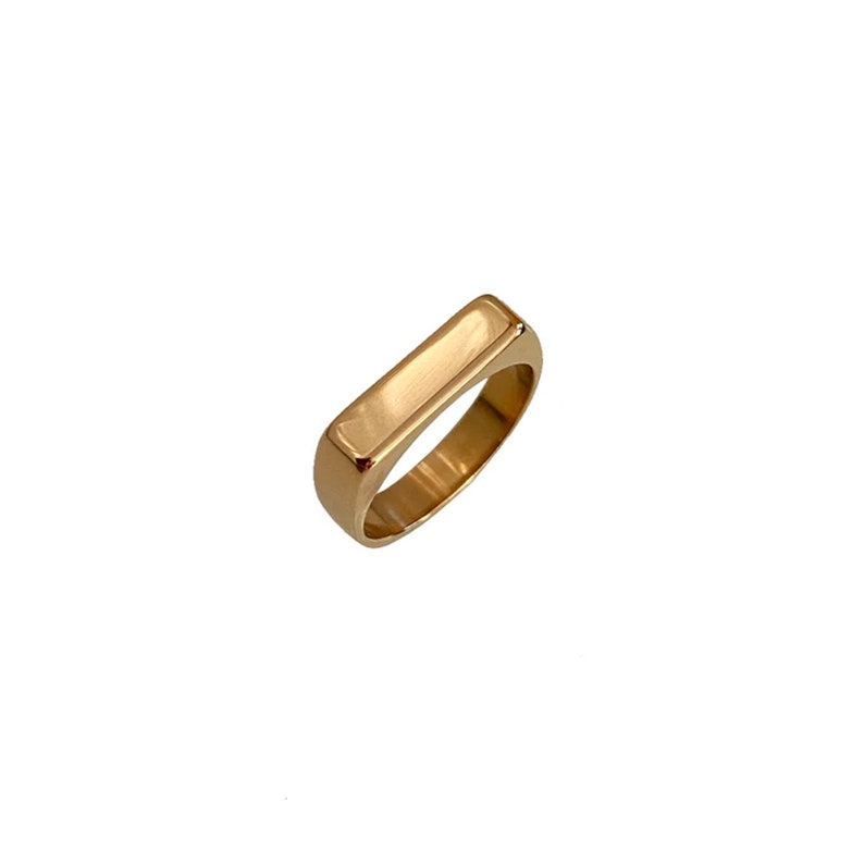 May include: A gold-toned ring with a rectangular band.