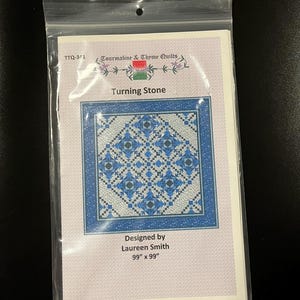 May include: Quilt pattern for a Turning Stone quilt, designed by Laureen Smith. The pattern features a blue and white geometric design with a 99 inch by 99 inch finished size.
