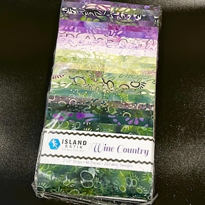 May include: A bundle of 40 fabric strips in 20 designs, labeled Island Batik Wine Country, featuring purple and green batik patterns. The package contains 2 1/2 inch strips wrapped in clear plastic, showcasing a variety of abstract botanical motifs.
