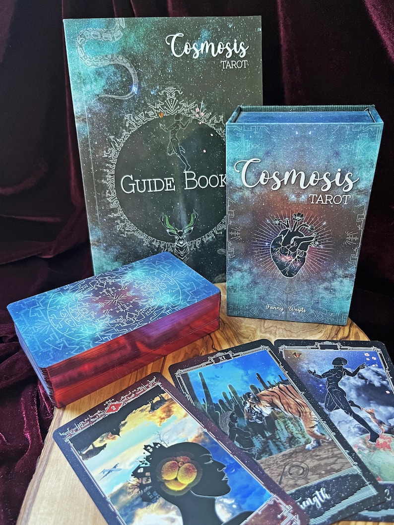 May include: A Cosmosis Tarot deck set including a guidebook, a rectangular storage box with a heart illustration, a deck of cards with blue and red edges, and three individual tarot cards featuring a silhouette, a tiger, and a surreal head profile.