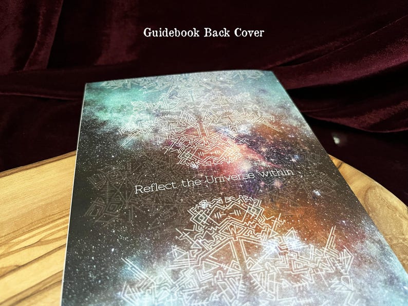 May include: A rectangular guidebook back cover featuring a dark space-themed background with nebula colors of teal, orange, and purple. The cover displays white geometric line art patterns and the text "Reflect the Universe within" in white.