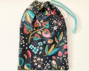 Waterproof bag for wet swimsuits, made of navy blue coated cotton fabric with multicolored floral patterns