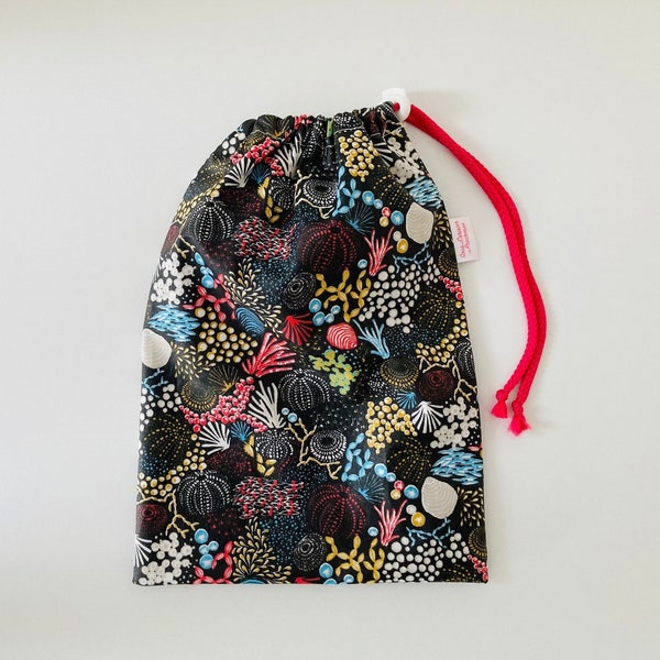 Waterproof bag for wet swimsuits in black coated cotton fabric with marine patterns
