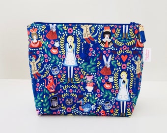 Blue fabric toiletry bag with Alice in Wonderland motifs