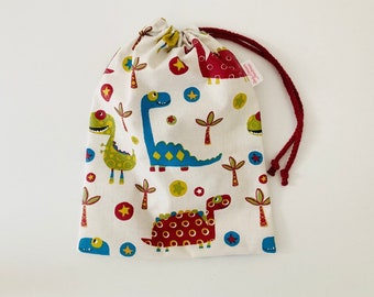 Waterproof bag for wet swimsuits in off-white coated cotton fabric with colorful dinosaur patterns