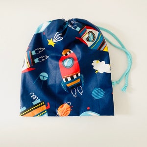 Wasserdichte Tasche für nasse Badeanzüge aus marineblau beschichtetem Stoff mit Raketenmuster.