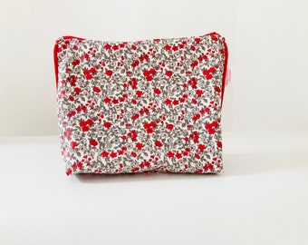 Waterproof toiletry bag in coated fabric with small red and gray flower pattern