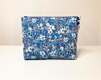 Toiletry bag in Liberty fabric with shades of blue flowers.