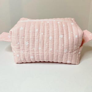 Small quilted makeup bag in powder pink double gauze cotton fabric with small white stars.