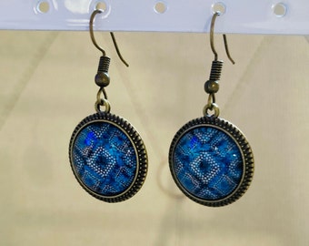 Round earrings in bronze-colored metal with geometric patterns in blue tones