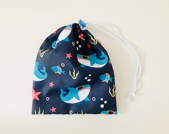 Waterproof bag for wet swimsuits in navy blue waterproof fabric with shark patterns with glasses.