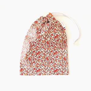 Wasserdichte Tasche für nasse Badebekleidung aus beschichtetem Baumwollgewebe mit kleinen orangefarbenen Liberty-Blumenmustern.