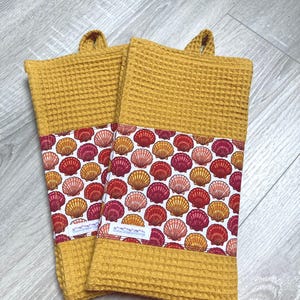 Tea towel in mustard-colored honeycomb cotton fabric and decorative strip in shell-patterned cotton fabric