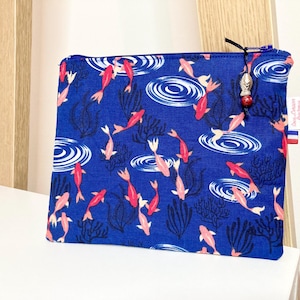 Astuccio piccolo in tessuto di cotone blu con motivi di pesci rossi.