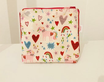 Toiletry bag in coated fabric with unicorn, rainbow and heart patterns lined in coated white linen