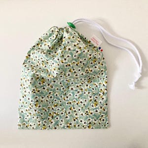 Wasserdichte Tasche für nasse Badeanzüge aus hellgrün beschichtetem Baumwollstoff mit Liberty-Mustern und kleinen weißen Blumen.