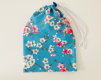 Waterproof bag for wet swimsuit in blue coated cotton fabric with Japanese white and pink cherry blossom patterns