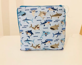 Toiletry bag in sky blue coated fabric with small shark patterns lined in coated white linen
