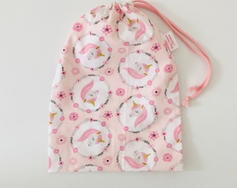 Waterproof bag for wet swimsuits in pale pink coated cotton fabric with unicorn patterns