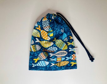 Waterproof wet swimsuit bag in blue coated cotton fabric with multicolored fish patterns