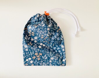 Waterproof bag for wet swimsuit in blue coated cotton fabric with small multicolored flower patterns