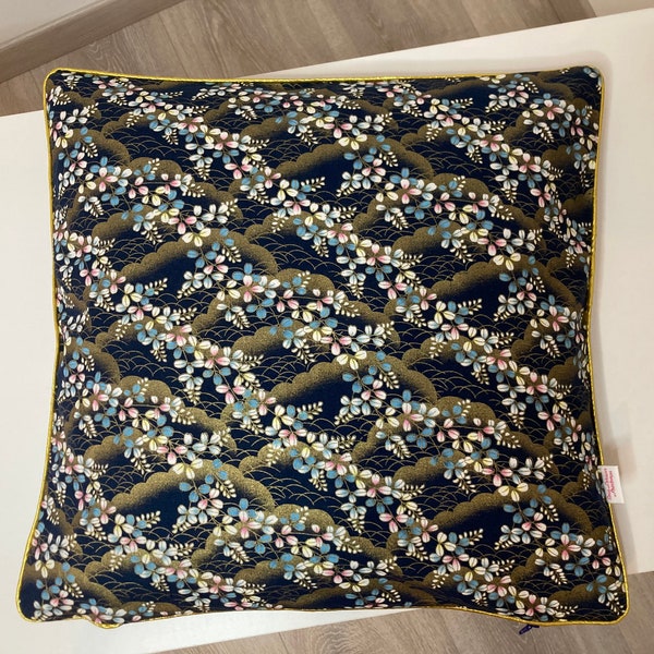 Housse de coussin 40x40cm en tissu japonais bleu marine avec des fleurs roses bleues très clair et dorées gansé en doré.