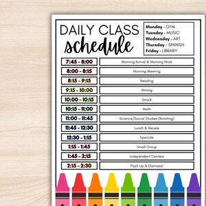 May include: A white daily class schedule with a black border. The schedule includes times, subjects, and activities. The days of the week are listed on the right. Colorful crayons are at the bottom of the schedule.