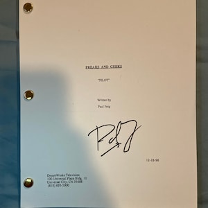 May include: A white script titled "FREAKS AND GEEKS" with "PILOT" in quotation marks. The script is signed by Paul Feig and dated 12-18-98. The DreamWorks Television address is printed at the bottom.