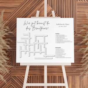May include: A white crossword puzzle with the title "Wie gut kennst du das Brautpaar?" and the names "Sabrina & Marc" and "20 MAI 2024". The puzzle has a grid of squares with numbers and clues listed vertically and horizontally.