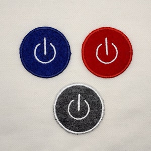 May include: Three embroidered iron-on patches with a white power button symbol on a blue, red, and gray background.