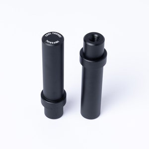 Puede incluir: Dos adaptadores de cámara de metal negro, uno con el texto "TOOL THEORY IMPERIAL" en la parte superior y el otro con un extremo roscado.