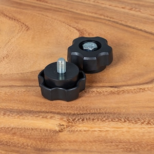 May include: Two black plastic knobs with a threaded metal screw. The knobs have a star-shaped design.