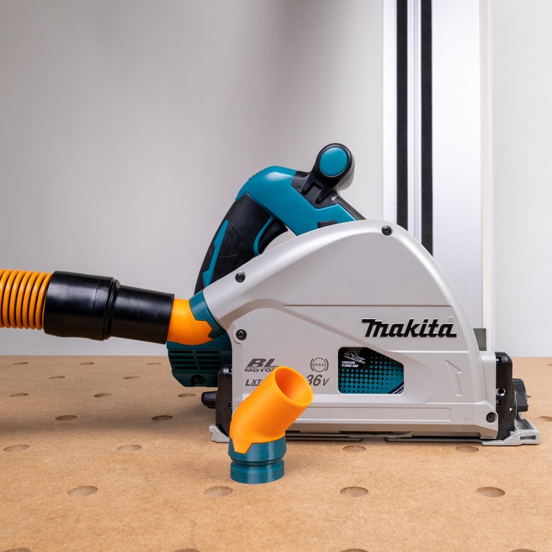 May include: A teal and gray Makita cordless circular saw with a black and orange dust collection hose and a black and orange dust collection adapter. The saw has a black and orange BL motor and a 36V battery.