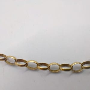 May include: A gold chain necklace with oval links.